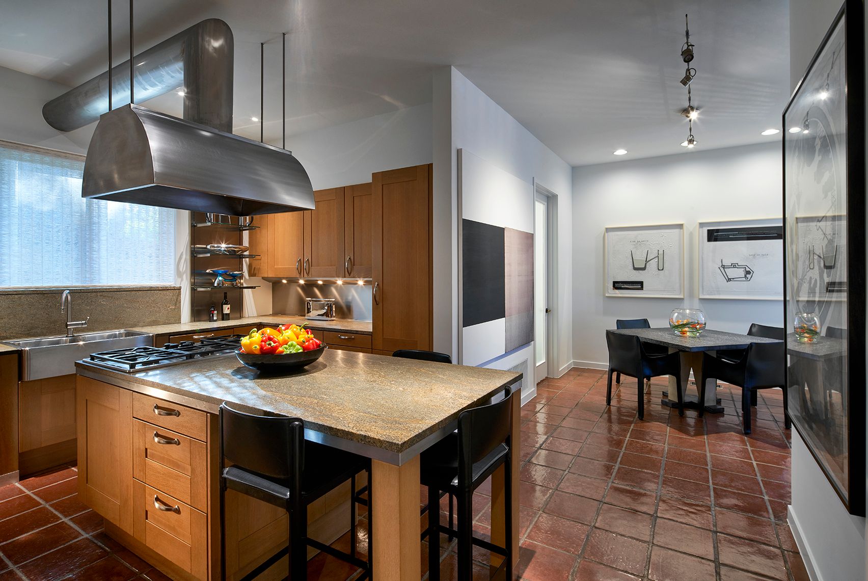 kitchen dining area with view of steel range hood