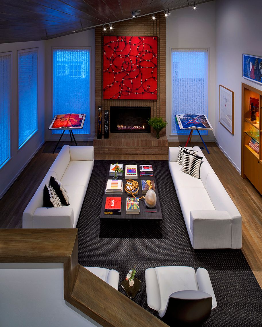 view from upstairs looking down on living area with white sofas and fireplace