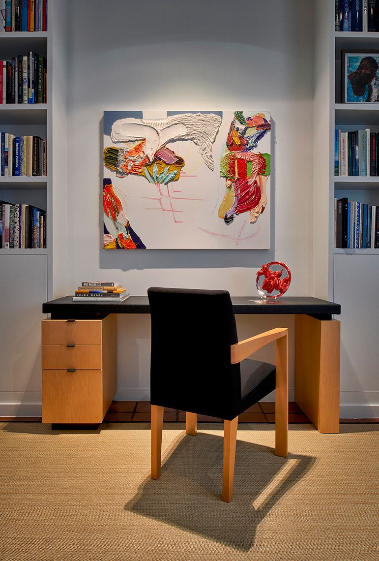 desk with chair and painting just above it