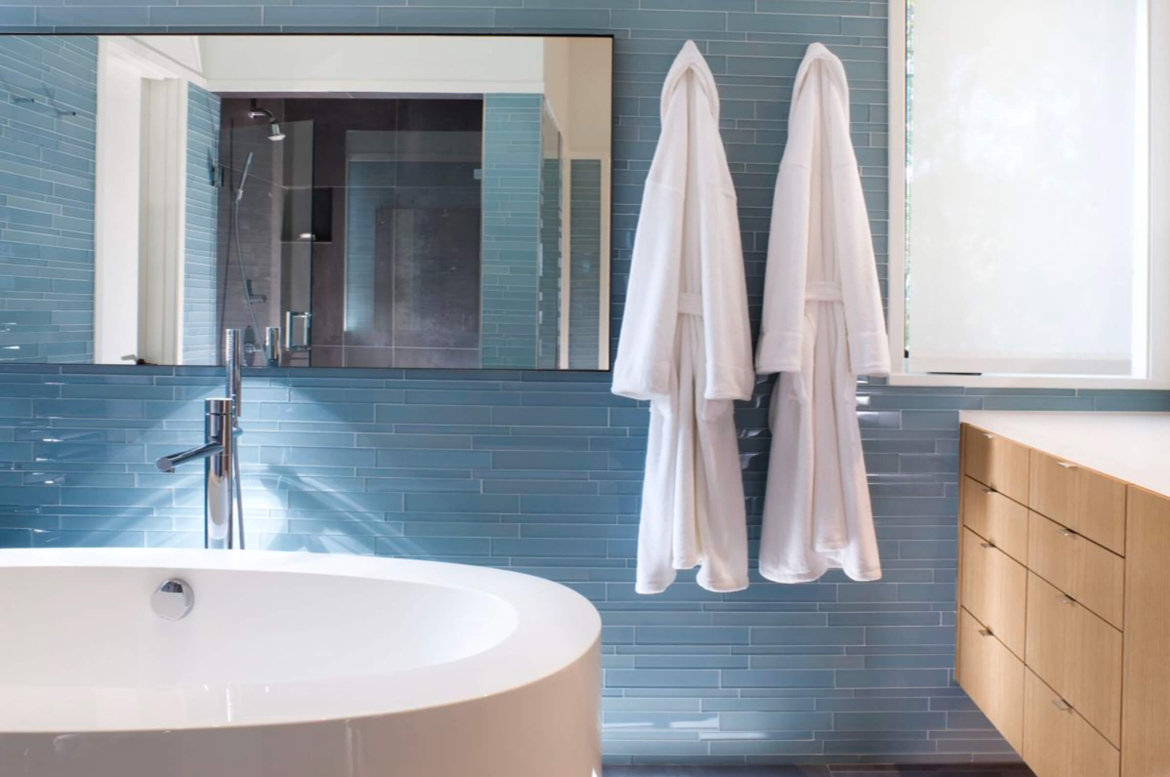 two robes hanging near an large round tub