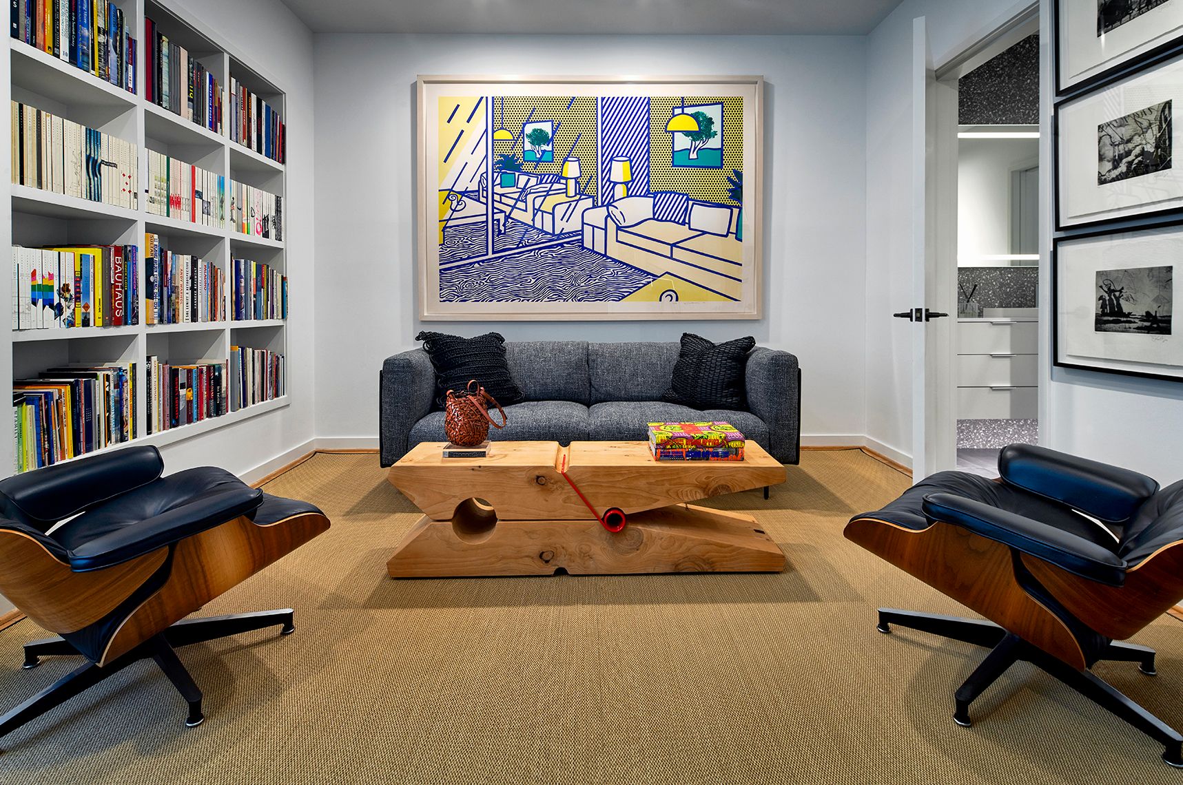 Photo of living room with bookshelves, painting and seating area