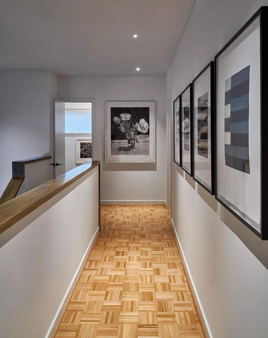 upstairs walkway with light wood parquet flooring