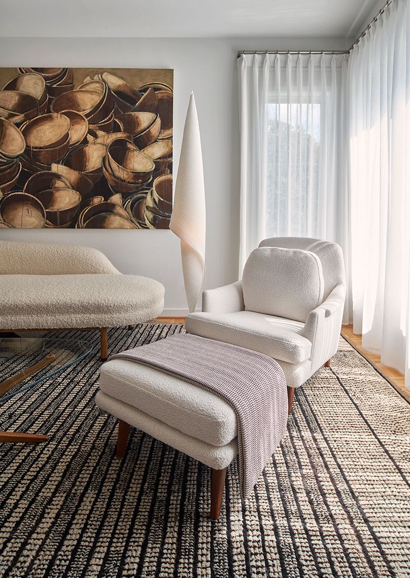 bedroom seating area with white lounge chair and sofa