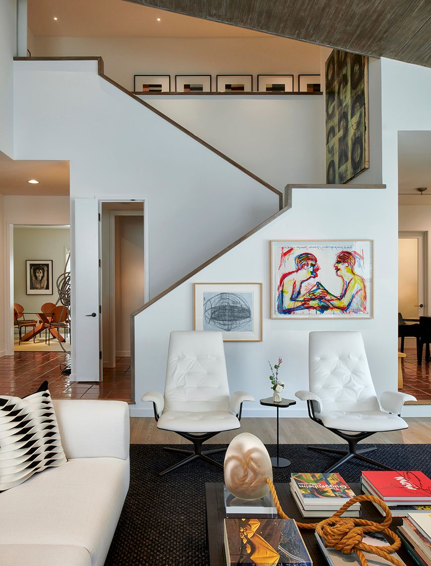 view from living area with white seating and stairwell to top floor